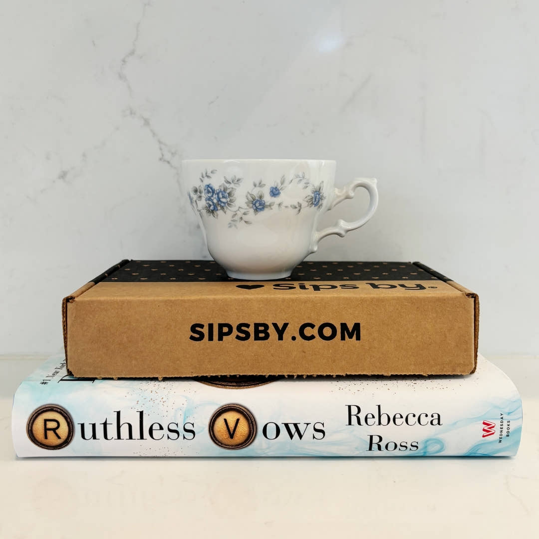 Stack of Ruthless Vows Tea Box with book and teacup