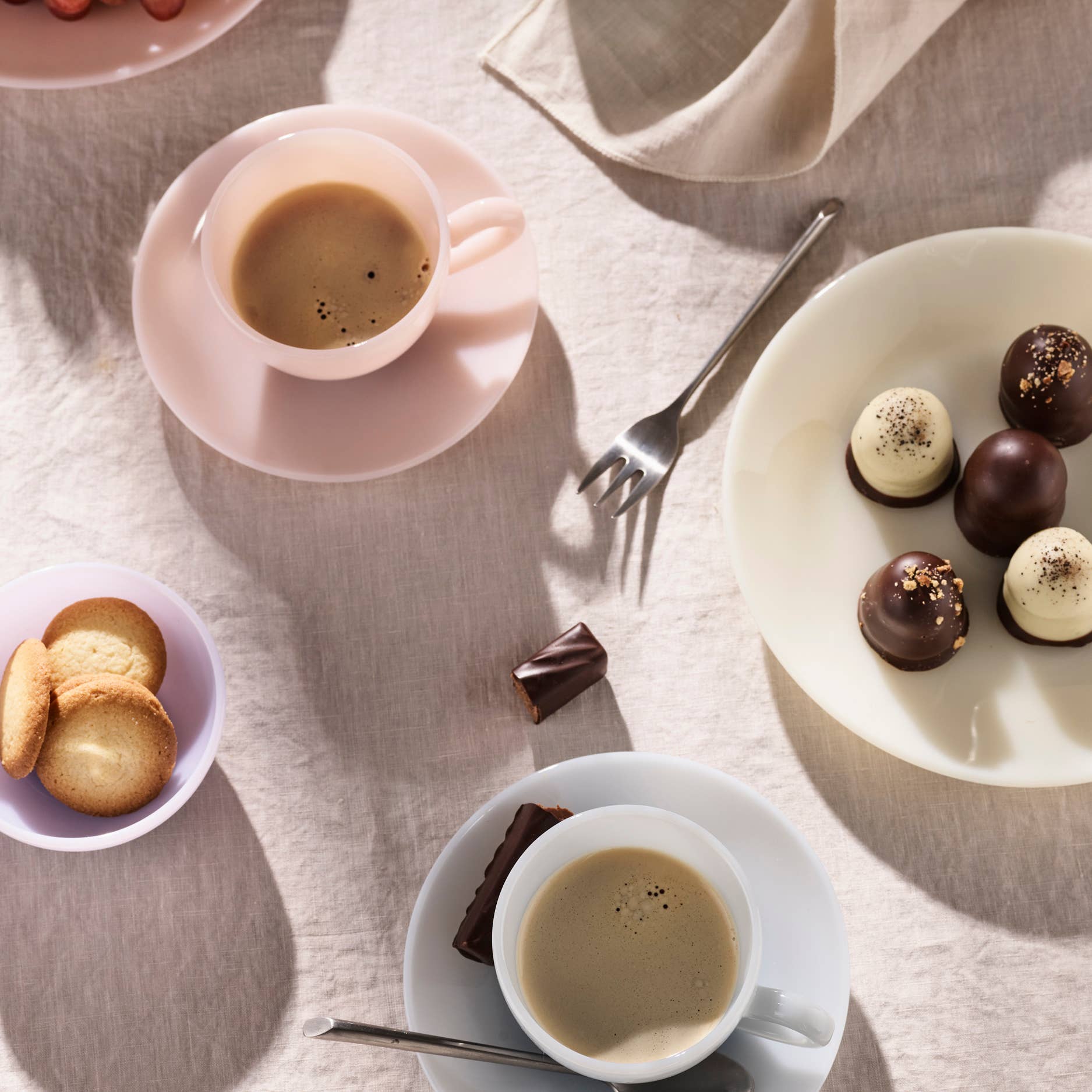 Lucie Kaas Almond Opal Milk Glass Teacup & Saucer tablescape with chocolate truffles