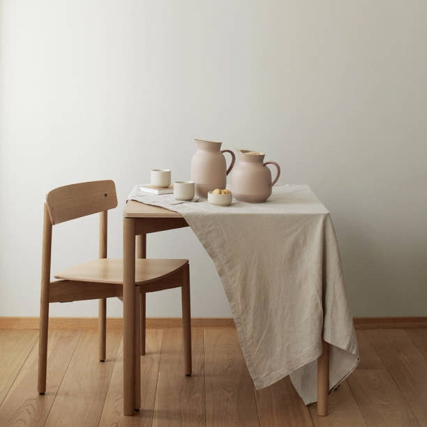Tablescape scene with Stelton Amphora Vacuum Tea Jugs in soft peach and two white mugs