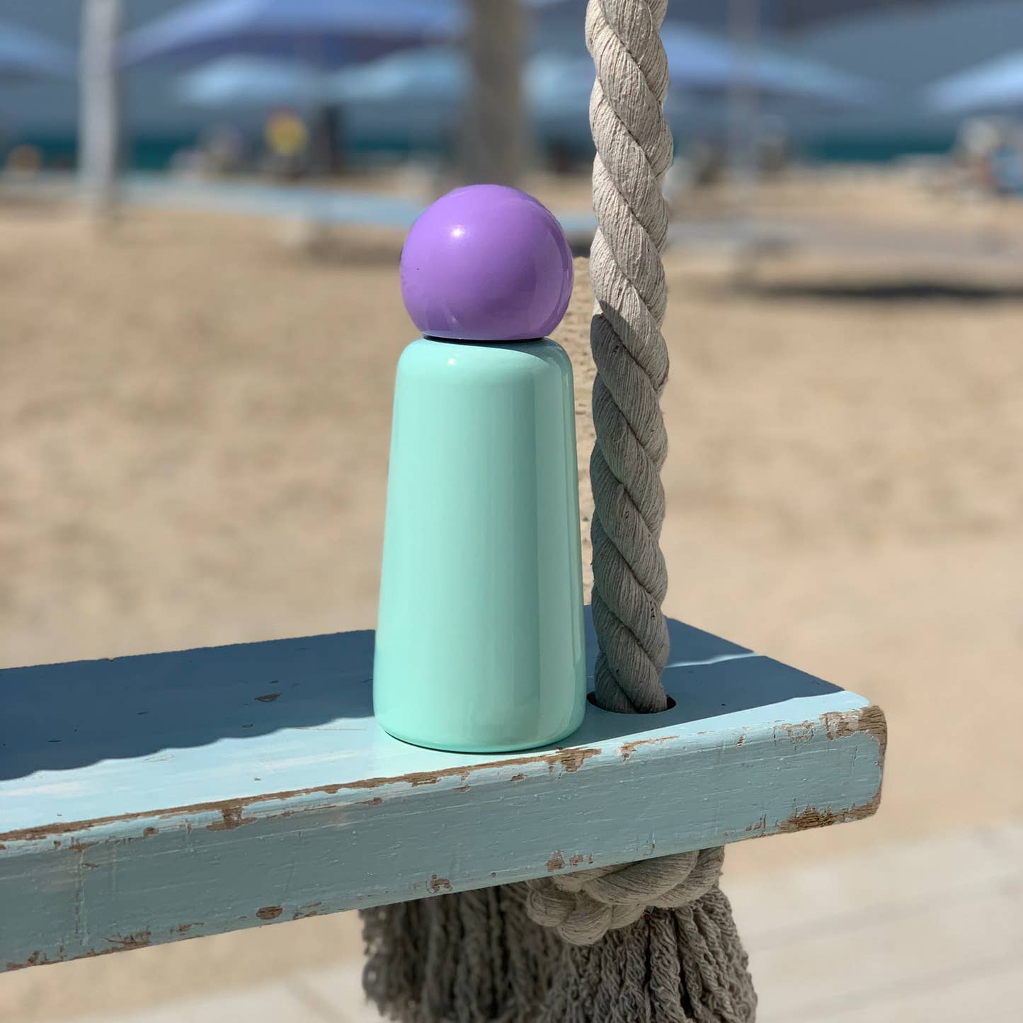 Mint & Lilac Skittle Stainless Steel Bottle on a wooden bench on a beach