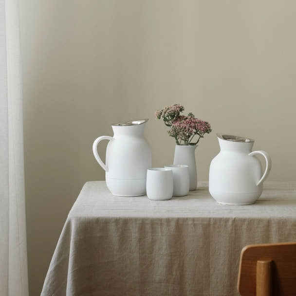 Tablescape scene with Stelton Amphora Vacuum Tea Jugs in white with two mugs and a flower vase