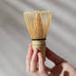 Hand holding  Zen Matcha's Bamboo Matcha Whisk