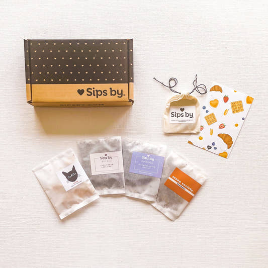 Sips by Box with four loose leaf brunch tea samples, a brunch tea postcard with strawberries, croissants, waffles, blueberries, and cups of tea, and biodegradable tea filters