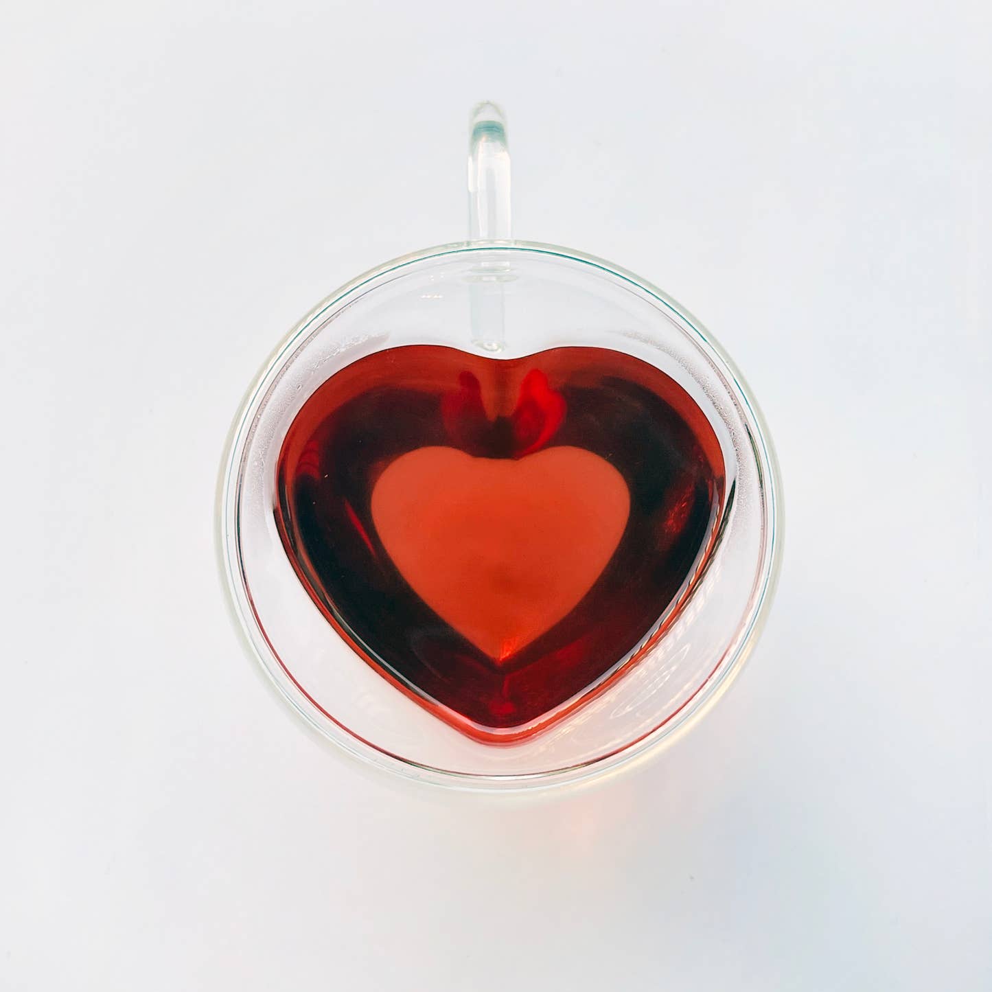 Glass heart mug with steeped Joyful tea by Your Botanical Friend