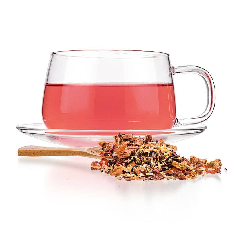 Steeped Raspberry Lemonade herbal tea by Tealyra in a clear tea mug with a wood spoon for loose leaf tea